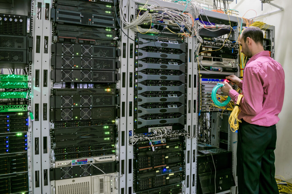 specialist working with optical internet wires in server room